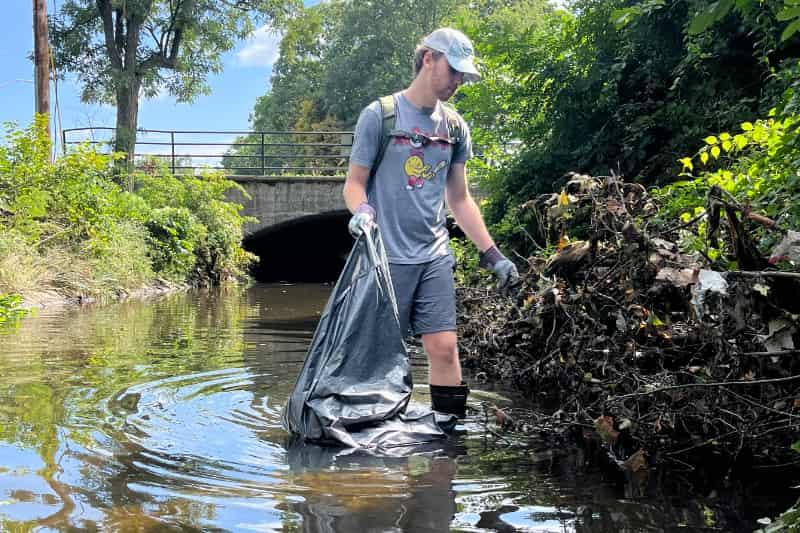 A student cleans up Beaver Brook